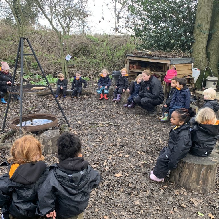 pupils sat around a camp fire