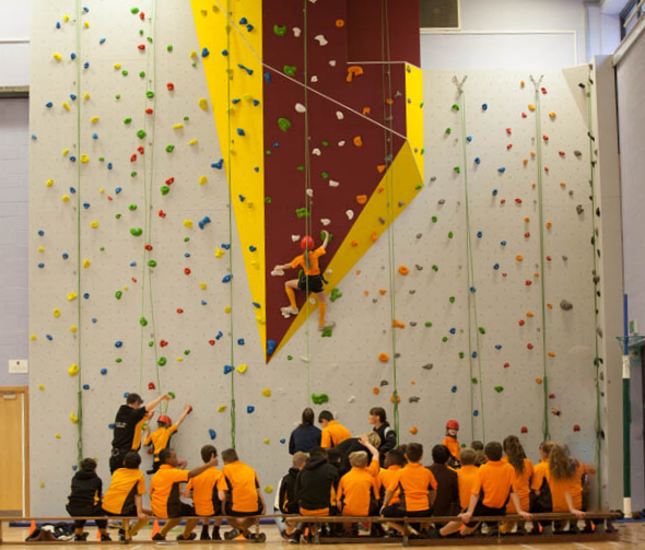 children in front of a rock climbing wall