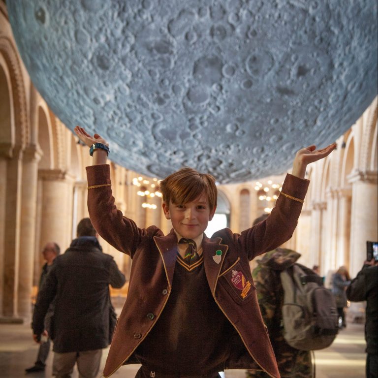 boy holding a large round object